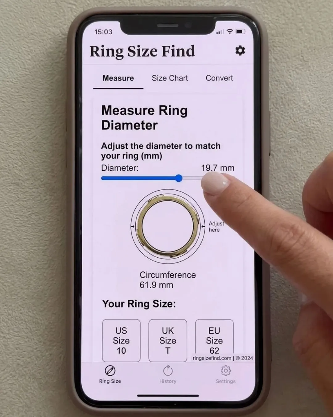 A smartphone screen displaying the Ring Size Find app, showing a physical gold ring placed on a digital measurement tool to find a US Size 10 ring.